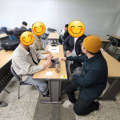 강의실 테이블에 둘러앉아 수강생들과 실습하는 모습