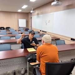회의실에서 노란 메모지를 두고 일대일로 진행한 컨설팅 미팅